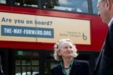 Jenny Jones, Baroness Jones of Moulsecoomb, talking to Norman Baker from Campaign for Better Transport beside a campaign-branded double-decker bus
