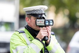 Police officer holding radar speed gun