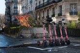Row of Voi scooters in front of building